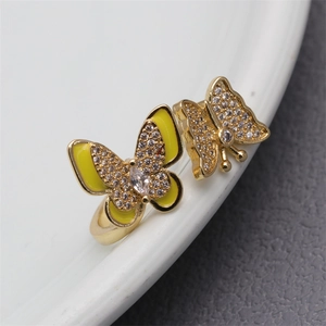 Detail of gold butterfly ring with yellow enamel and micro-pave cubic zirconia accents