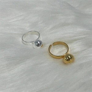 Detailed view of 925 sterling silver ball rings in gold and silver finish on plush fabric