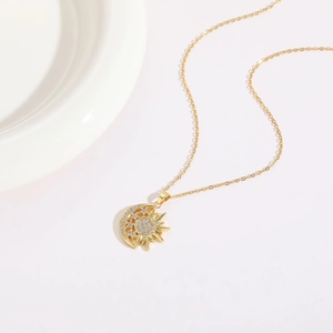 Detail of 14K gold plated sun and moon pendant necklace with sparkling zircon inlay