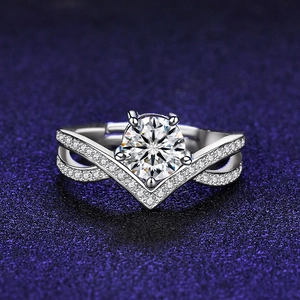 Detailed close-up of a silver ring featuring a six-prong round moissanite on a V-shaped band