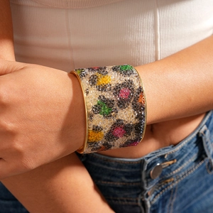 Dettaglio del bracciale rigido dorato regolabile con cristalli a motivo leopardato