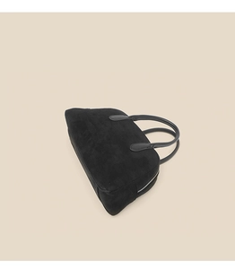 Top-down view of black suede bowling bag with smooth leather handles and zipper
