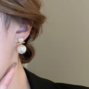 Detailed view of elegant double faux pearl earrings with a gold metal horizontal bar