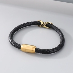 Detail of black braided leather bracelet with golden magnetic clasp and crystal infinity charm