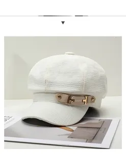 Detail of white textured newsboy cap with beige leather strap and gold metal UIUIU buckle