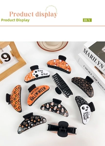 Gothic Halloween hair clips featuring pumpkins and ghosts on a white tabletop