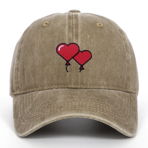 Detailed embroidery of two red heart balloons on a vintage washed cotton baseball cap