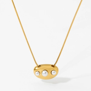 Collier chaîne serpent dorée avec trois perles organiques graduées sur fond gris minimaliste