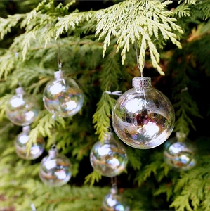 Clear PET Christmas ball ornaments hanging on green pine branches for holiday decoration