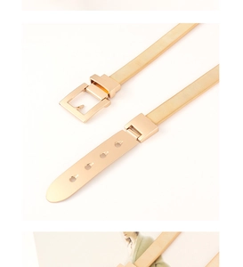 Detail view of golden elastic metal waist belt with adjustable square buckle and slim spring chain
