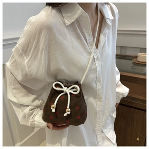 Brown corduroy bucket bag with red strawberry embroidery and white rope strap detail