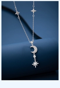 Macro shot of 925 sterling silver moon and star pendant with sparkling zircon inlay