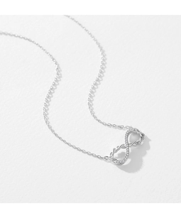 Macro shot of silver Mobius necklace pendant with pavé diamonds and delicate chain