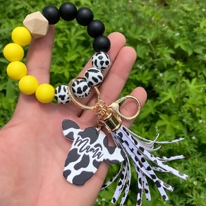 Close-up of leopard silicone bead bracelet with Mama cow tag and fringe tassel