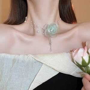 Close-up of light green tulle flower choker with pearls and rhinestone tassels