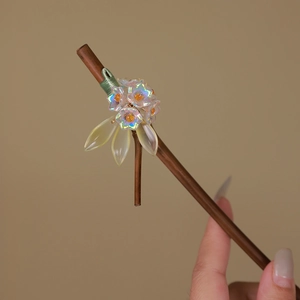 Detail of handcrafted bamboo hair pin with translucent glass flowers and green silk threads