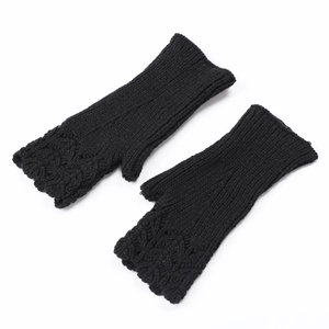 Detail of black knitted fingerless gloves with intricate scale pattern and open-thumb design