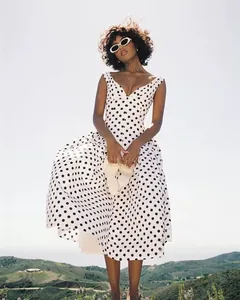 Elegante retro witte midi-jurk met zwarte stippen, mouwloos en voorzien van een V-hals