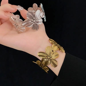Vintage metal flower bracelet in antique gold and matte silver finishes on model