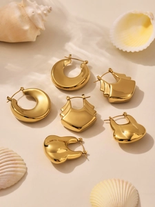 Détail de trois paires de boucles d'oreilles géométriques en acier plaqué or 18k