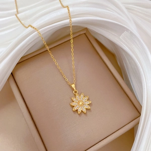 Macro shot of gold daisy flower pendant necklace with sparkling rhinestones on silk
