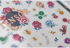 Macro detail of floral nail art stickers with embossed rose and bee patterns
