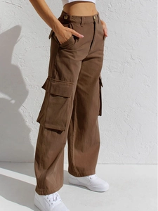 Detail der braunen Cargo-Jeans mit weitem Bein, Seitentaschen und Stoffstruktur am Model