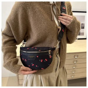 Detail of black crossbody bag with cherry print and golden fashion leather lettering