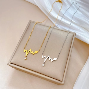 Minimalist heartbeat necklace with gold and silver finishes and zircon stone pendant
