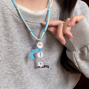 Detailed view of the snowman enamel pendant with tassel on a cord sweater necklace