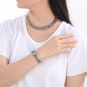 Close-up of silver Cuban link chain necklace and rhinestone bracelet set on a model