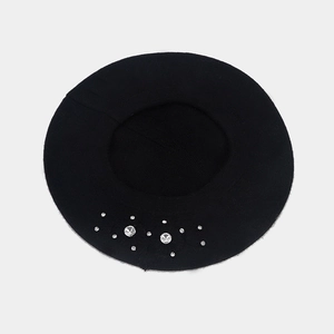 Detail of black knit beret with sparkling rhinestone floral accents on soft wool fabric