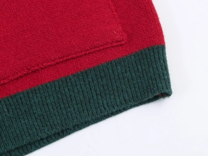 Détail du cardigan de Noël tricoté rouge et vert avec ourlet en tricot côtelé vert