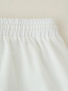 Detailed macro view of the elastic waistband on white cotton linen trousers with texture