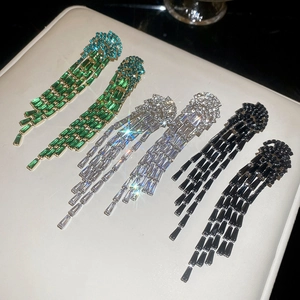 Détail de boucles d'oreilles méduses à pampilles avec zircons verts blancs et noirs