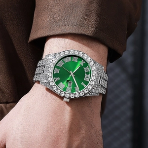 Detail of luxury men's silver watch with green Roman dial and iced-out crystals