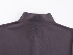 Detailed close-up of dark grey V-neck zipper collar and knit texture of yoga top