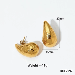 Macro shot of gold teardrop earrings with textured diamond patterns and size specs