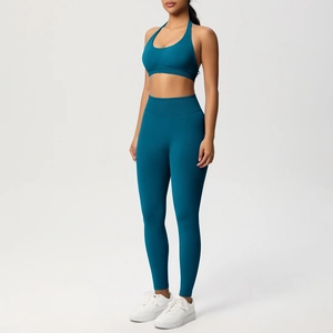 Dettaglio dei leggings da yoga a vita alta e del reggiseno sportivo in maglia blu petrolio