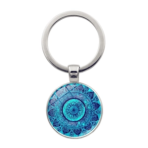 Macro detail of mandala pattern art glass pendant on polished metal keychain ring