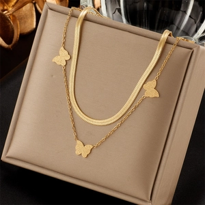 Close-up of double-layered gold butterfly necklace with sleek snake chain in jewelry box