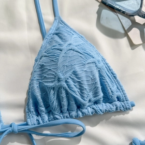 Detailed close-up of light blue halter bikini top with crinkle seersucker texture fabric