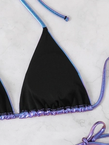 Close-up of bikini top with black matte fabric and metallic purple holographic trim