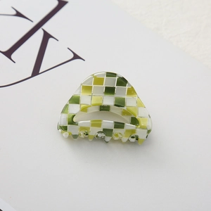 Close-up of a green and white checkered hair claw clip in faux acetate finish