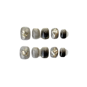 Handmade press-on nails with black marble ink design and heart-shaped 3D crystal accents