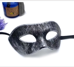 Detailed close-up of antique silver brushed masquerade mask with black ribbon ties