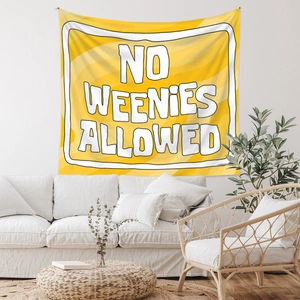 Detailed view of yellow tapestry with No Weenies Allowed text in a cozy home setting