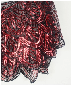 Close-up of intricate red and black sequin beadwork on black mesh shrug with wavy hemline