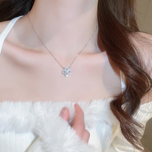 Close-up of sparkling zircon clover pendant necklace on neck for refined fashion style