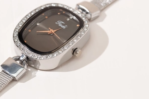 Macro shot of oval women watch with sparkling rhinestones and silver mesh steel band
